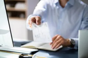 Insurer Hands Giving Cheque To Policy Holder
