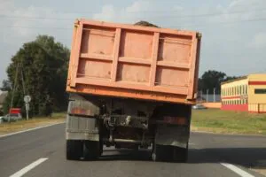 Heavy overloaded dump truck with lurch carries sand 