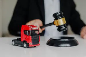 Male Judge hitting Gavel off a block in courtroom. Toy cargo truck on the table.