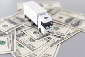 White toy truck lie on dollars