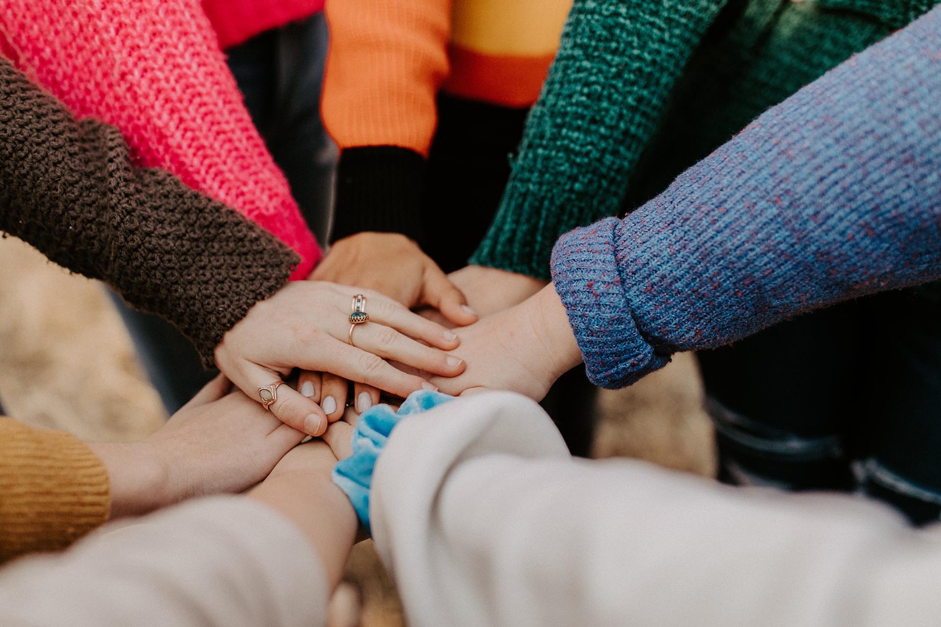 group of people with hands in circle for teamwork