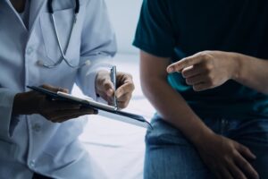 Doctor and patient discussing something while sitting at the table.