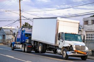 Image of a large truck making a wide right turn at an intersection, illustrating potential danger to nearby vehicles.