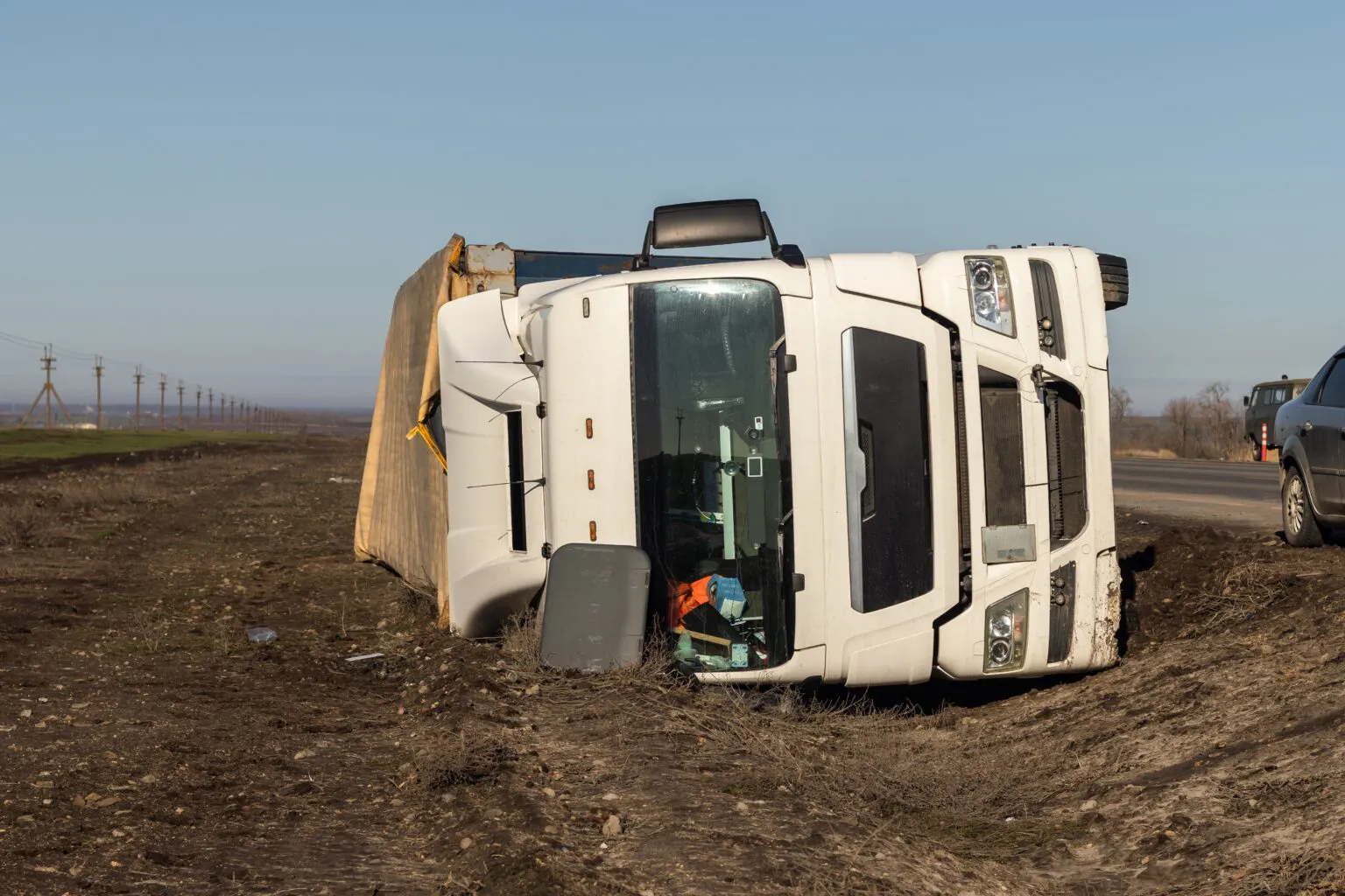 Overturned semi truck in a ditch beside a highway