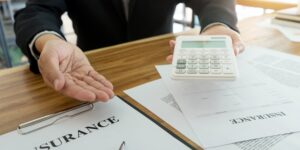 Insurance adjuster presenting a calculator and settlement documents, symbolizing a low first car accident settlement offer and negotiation process.