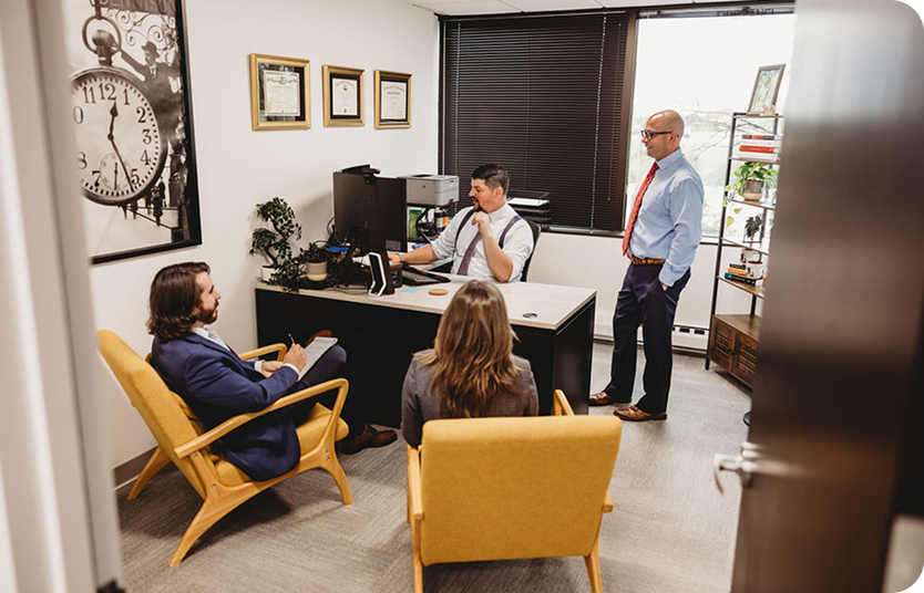 The Vito & Dollenmaier Law team meeting in an office